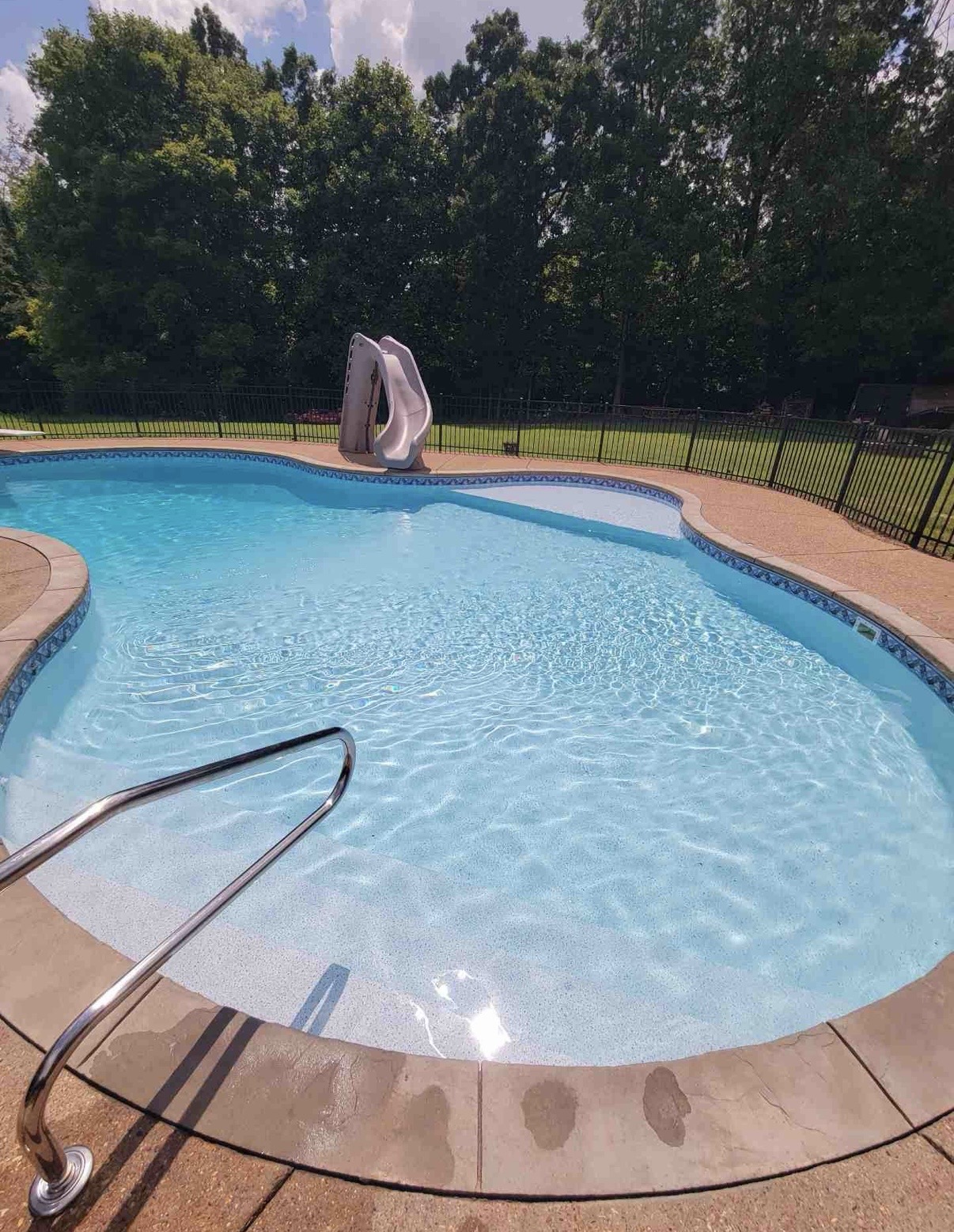 Freeform in-ground pool with a slide, maintained by Clarksville Pool & Leisure