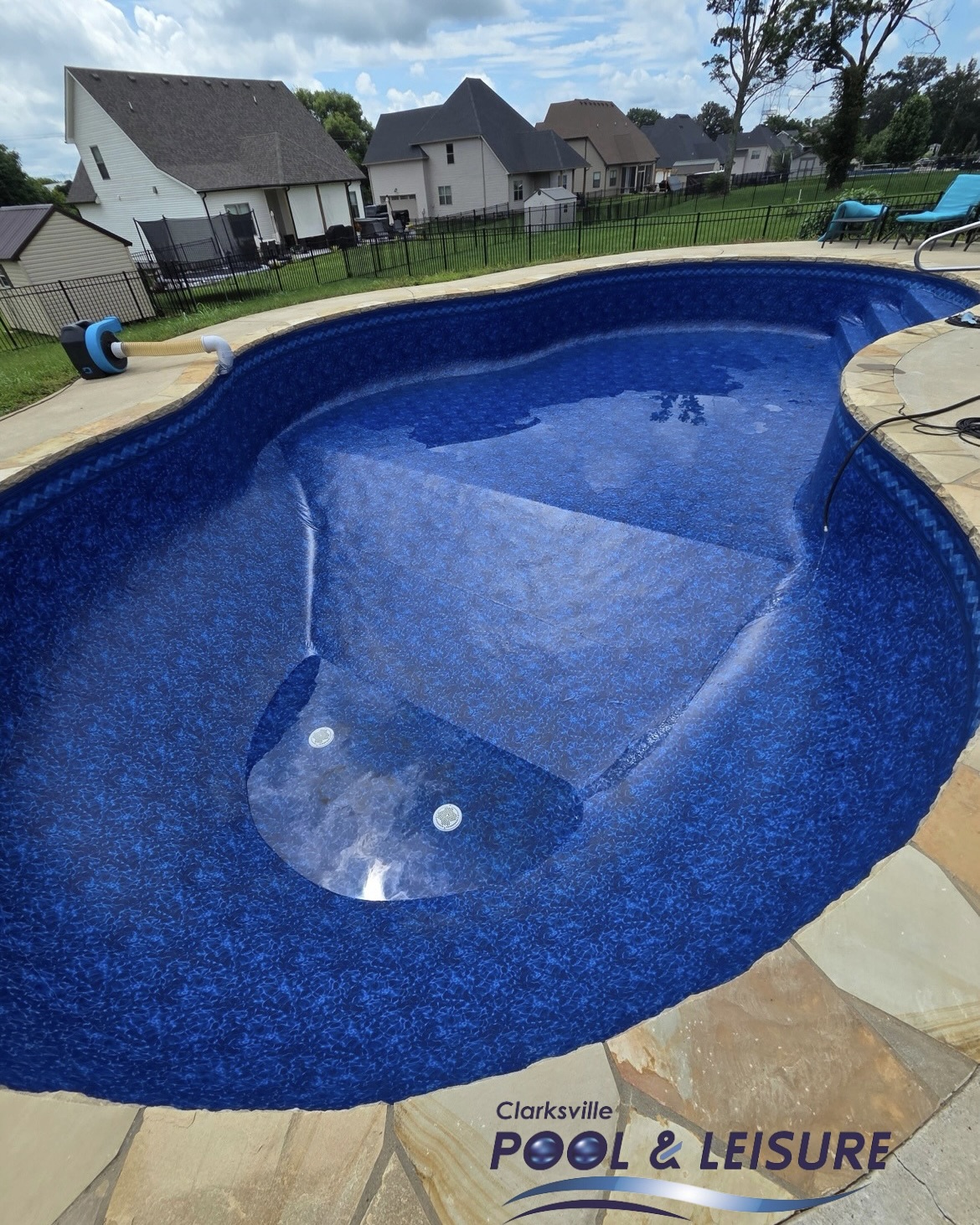Newly installed deep blue vinyl liner in a freeform in-ground pool